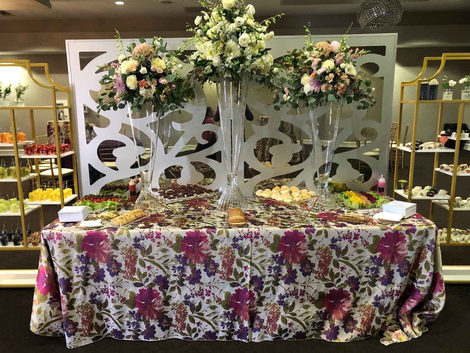 Floral dessert table with tall vase arrangements and gold étagères